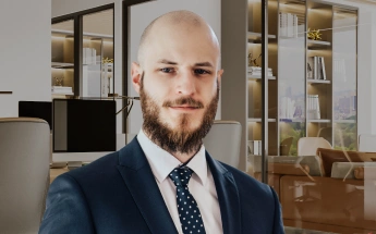 Bartosz Duda, adwokat specjalizujący się w sprawach dotyczących wypadków drogowych, na tle eleganckiego biura.