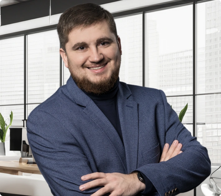 Sebastian Borowy, radca prawny specjalizujący się w sprawach dotyczących wypadków w pracy, na tle nowoczesnego wnętrza.